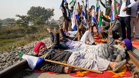  Farmers block railway tracks as part of their state-wide 'Rail Roko' protest to press the Centre into accepting their various demands, including a legally binding minimum support price for crops, on the outskirts of Amritsar, Wednesday.