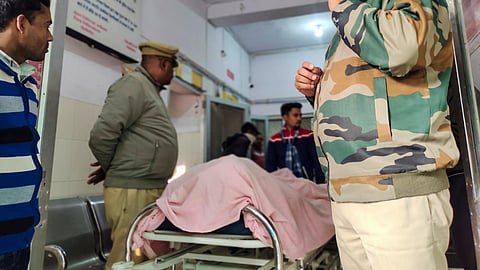 Police personnel and others stand near the body of one of the three terror suspects who, allegedly involved in the grenade attack in Gurdaspur, were killed in an encounter with a joint team of Uttar Pradesh and Punjab police, at a hospital, in Pilibhit.