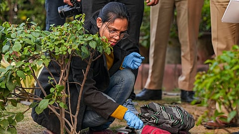 A member of the forensic team of Delhi Police Crime Branch conducts investigation at the spot where a man tried to immolate himself near the Railway Bhawan opposite the new Parliament building, in New Delhi, Wednesday, Dec. 25, 2024. 