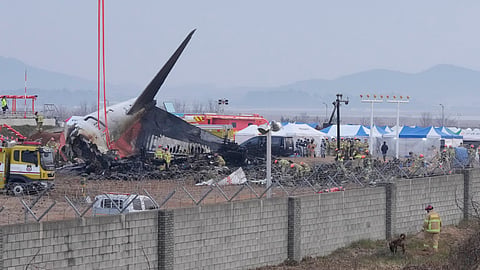Rescue team members work at the site of a plane fire at Muan International Airport in Muan, South Korea, Monday, Dec. 30, 2024. 