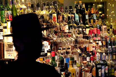 FILE - Bottles of alcohol sit on shelves at a bar in Houston, June 23, 2020. 