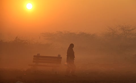 A person takes a walk on a cold and foggy winter morning, in Gurugram, Thursday, Jan. 9, 2025. 