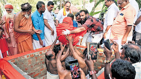 The body of Gopan Swami being placed for burial by his children and relatives, near his house at Aralumoodu near Neyyattinkara in Thiruvananthapuram 
on Friday.