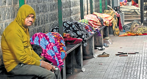 The presence of a stray dog isn’t as intimidating as the chill of the night for a woman and a man, huddled together on a bench outside Victoria Hospital in Bengaluru 