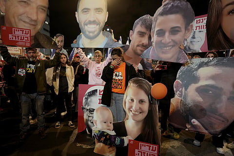 Demonstrators hold portraits of hostages held by Hamas in the Gaza Strip during a protest calling for their immediate release in Tel Aviv, Israel, Saturday Jan. 18