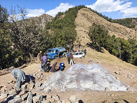 People dig a grave for the burial of Yasmeen Kouser, the 17th victim of the 'mysterious' illness, in Badhaal village of Rajouri district,