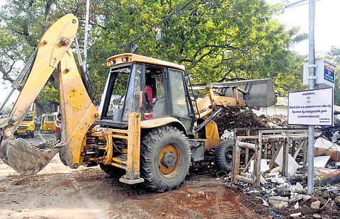 A GCC worker removing construction and demolition waste illegally dumped along Swami Sivananda Salai 