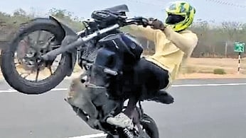 Biker from Tiruchy district violating traffic rules and doing bike stunt at middle of the road 