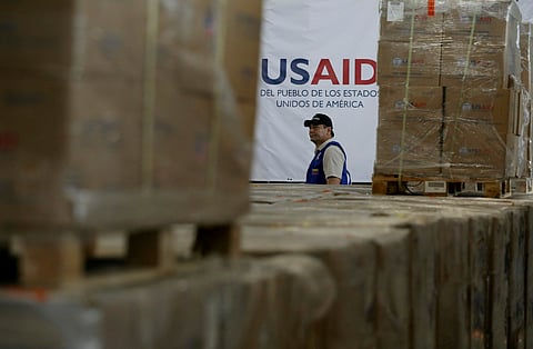 A man walks past boxes of USAID humanitarian aid at a warehouse at the Tienditas International Bridge on the outskirts of Cucuta, Colombia, Feb. 21, 2019, on the border with Venezuela. 