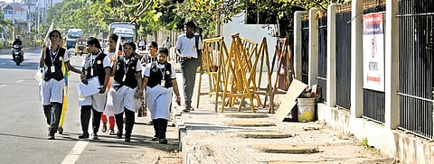 Students walk on the road as barricades occupy a footpath at Chepauk 