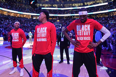 From left to right, Toronto Raptors forwards Bruce Brown, Scottie Barnes and Chris Boucher react as fans boo the United States national anthem before NBA basketball game action against the Los Angeles Clippers in Toronto, Sunday, Feb. 2, 2025. 