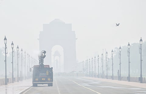 An anti-smog gun on a multi-purpose vehicle sprays water droplets to curb air pollution at Kartavya Path, in New Delhi.