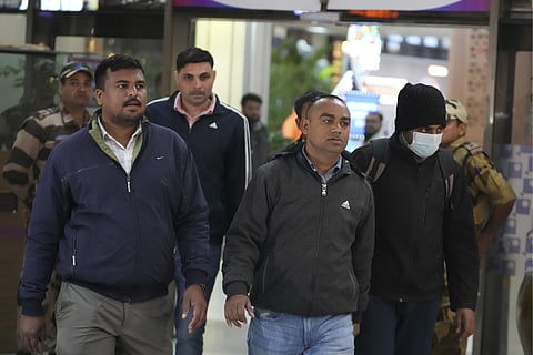 Police officials escort an immigrant man deported from the United States, right, who was among those who arrived in a U.S. military plane Wednesday in Amritsar, upon his arrival at the Ahmedabad airport in India, Thursday, Feb. 6, 2025. 