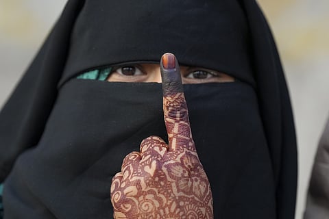 A woman shows her inked finger after casting her vote at a polling booth during the Delhi Assembly elections, near Turkman Gate, in New Delhi, Wednesday, Feb. 5, 2025.