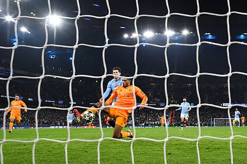 Real Madrid's midfielder Jude Bellingham shoots and scores his team's third goal during the UEFA Champions League football match between Manchester City and Real Madrid on February 11, 2025. 