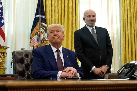 President Donald Trump listens to a question from a reporter as Commerce Secretary nominee Howard Lutnick watches after Trump signed an executive order in the Oval Office of the White House, Thursday, Feb. 13, 2025, in Washington. 