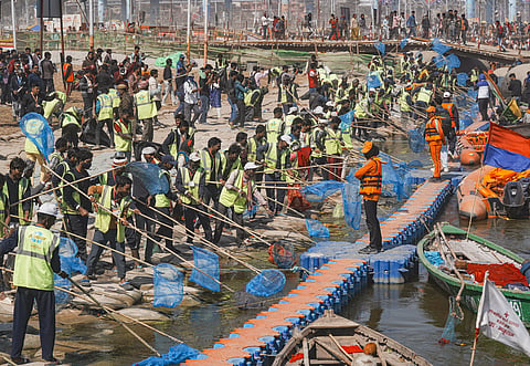 Sanitation workers clean a ghat at the Sangam area during the ongoing Maha Kumbh Mela, in Prayagraj, Uttar Pradesh, Friday, Feb. 14, 2025.