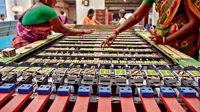 A worker carefully stacks freshly dipped matchsticks for drying at a factory in Kovilpatti, Tamil Nadu.