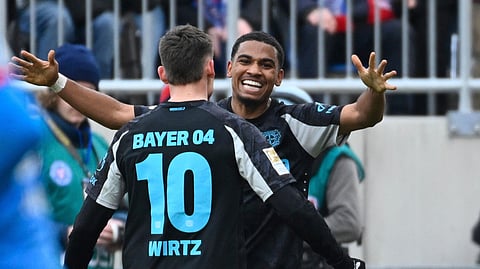 Leverkusen's Amine Adli, right, celebrates scoring with teammate Florian Wirtz during the Bundesliga soccer match between Holstein Kiel and Bayer Leverkusen at Holstein-Stadion, Kiel, Germany, Saturday Feb. 22, 2025.