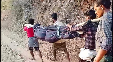 Tribals walking on the damaged road carrying Mani’s body in a doli
