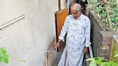 S Babu showing the dried-up drinking water tap at his residence on Kochar Road
