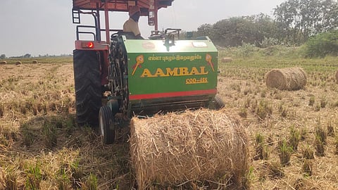 A round straw baler bundling paddy straw from a harvested field in Chithirakkudi village near Thanjavur 