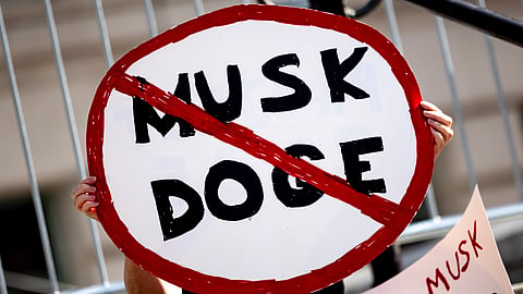 A demonstrator holds a sign during a rally to protest President Donald Trump and Elon Musk policies Feb. 17, 2025, in Los Angeles.