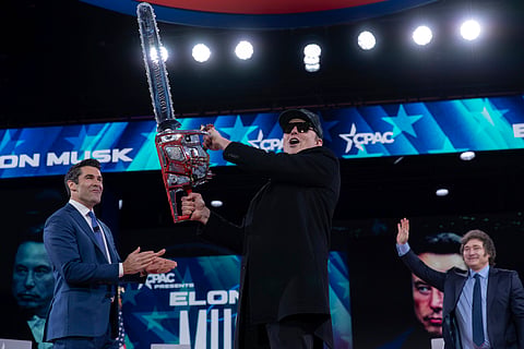 Elon Musk, left, receives a chainsaw from Argentina's President Javier Milei, right, as they arrive speaks at the Conservative Political Action Conference, CPAC, at the Gaylord National Resort & Convention Center.