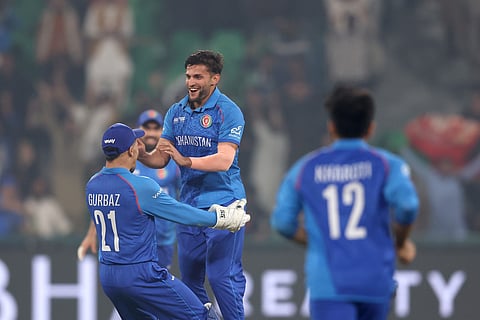 Azmatullah Omarzai celebrates with  teammates after taking a wicket