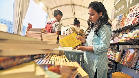 A girl checks out books at the ‘Pustaka Mela’ organised for the first time at Vidhana Soudha, on Thursday