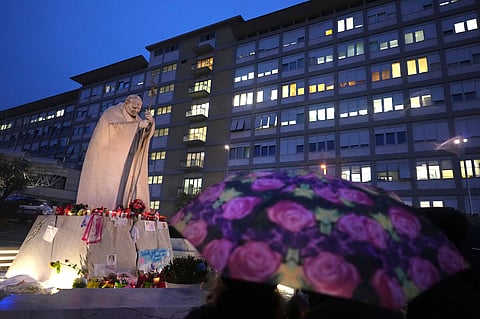 People shelter from the rain as they pray for Pope Francis in front of the Agostino Gemelli Polyclinic, where the Pontiff has been hospitalized since Feb.14, in Rome, Saturday, March 1, 2025. 
