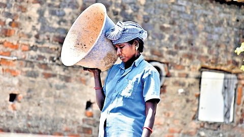 A labourer covers her face from the sun while at work 