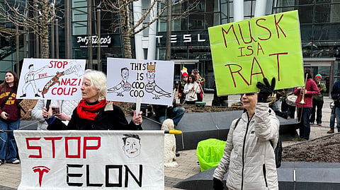 Protesters rally outside of a Tesla store in Boston, Saturday, March 1, 2025, against the company's CEO, Elon Musk, who is leading an effort to cut government jobs on behalf of President Donald Trump.