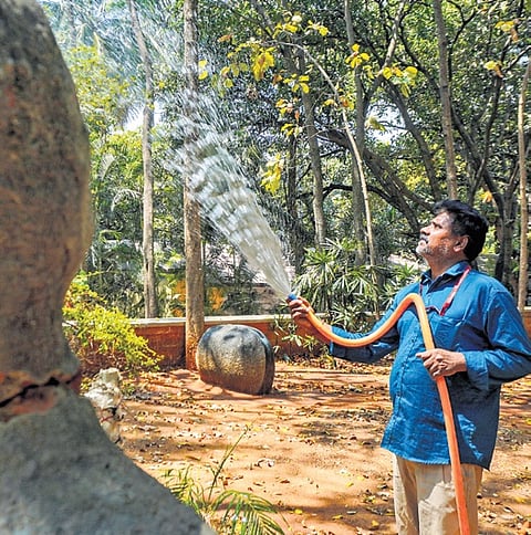 With the onset of summer, a man waters plants at  Karnataka Chitrakala Parishath in Bengaluru 