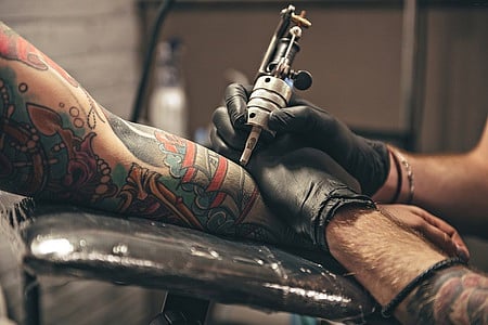 Close up tattoo machine. Man creating picture on hand with it in salon. Image used for representational purpose only.