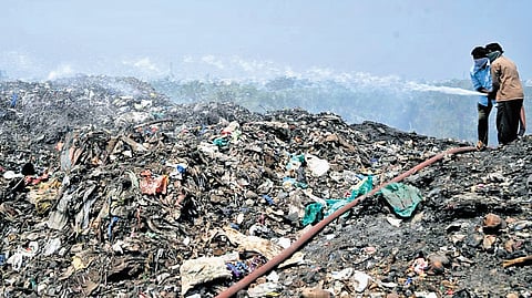 Sanitation workers try to douse a spontaneous fire that erupted at the dumping yard in Karimnagar on Tuesday