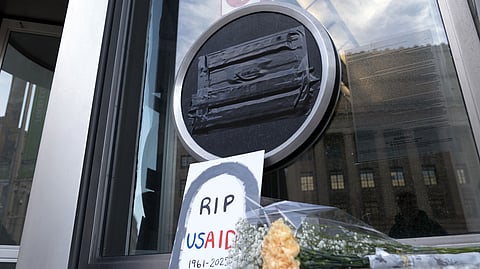 Flowers and a sign are placed outside the headquarters of the US Agency for International Development, or USAID, Feb. 7, 2025, in Washington. 