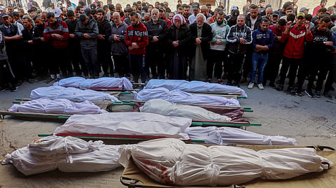 Palestinian mourners pray over the bodies of victims of overnight Israeli airstrikes on the Gaza Strip at Al-Ahli Arab hospital, also known as the Baptist hospital, in Gaza City ahead of their burial on March 18, 2025.