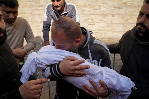 A Palestinian man holds the body of his 11 month-old nephew Mohammad Shaban, killed in an Israeli army airstrikes at the Al-Ahli Hospital in Gaza City, Tuesday, March 18, 2025. 