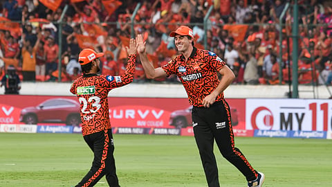 Sunrisers Hyderabad players Pat Cummins and Ishan Kishan celebrate the wicket of Rajasthan Royals batter Riyan Parag.