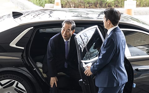 South Korean Prime Minister Han Duck-soo, left, arrives at the Government Complex in Seoul, South Korea, Monday, March 24, 2025.