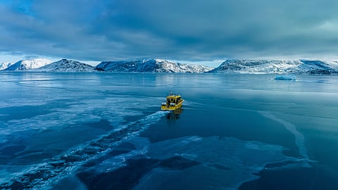 A boat rides though a frozen sea inlet outside of Nuuk, Greenland, March 6, 2025. 
