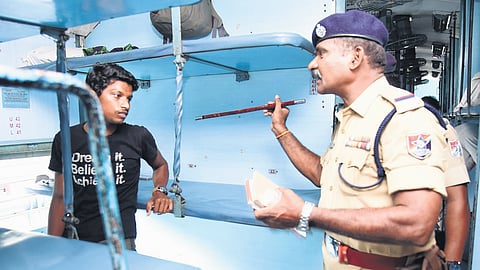 A cop speaks to a young passenger inside a train
