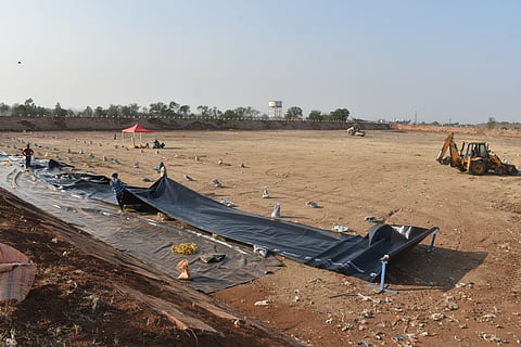 Workers engaged in restoration work of a dormant lagoon, which is being revamped to serve as a water reservoir. 