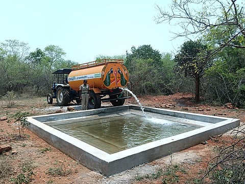 Forest department officials filling a concrete trough with water for wildlife at TN Palayam, under of Sathyamangalam Tiger Reserve, of Erode district. 