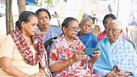 Munambam protesters eagerly watch the live debate on the Waqf Amendment Bill on mobile phone on Wednesday on the premises of Our Lady of Velankanni Church, Kadappuram 