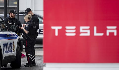 Officers from Ottawa Police Service (OPS) are seen at a Tesla Service and Showroom centre after it was damaged with pink spray paint in Ottawa, on Monday, March 31, 2025. 
