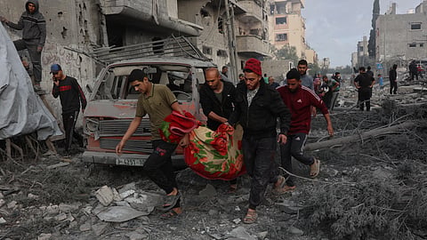 Palestinians carry the body of a victim after it was dug out from the rubble of a destroyed school, a day after it was hit by an Israeli strike, in the al-Tuffah neighbourhood of Gaza City on April 4, 2025. 