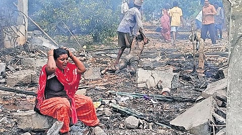 A woman grieves the death of her loved ones at the blast site on Sunday. 