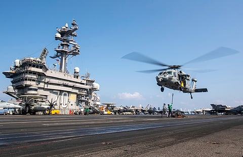 This photograph released by the US Navy shows an MH-60S Sea Hawk helicopter hovering over the USS Carl Vinson aircraft carrier while operating in the Middle East on April 12, 2025.
